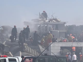 Redningsarbeidere arbeider på et sammenrast hus