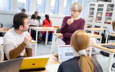 Lærere og videregående-elever diskuterer i klasserom 