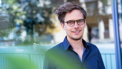 Portrett a smilende ung mann med briller