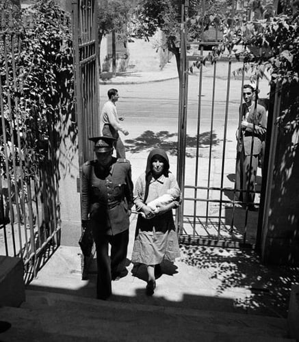 ei mor som leverer barnet sitt til barneheimen i Athen, følgde av ein politimann, i Athen