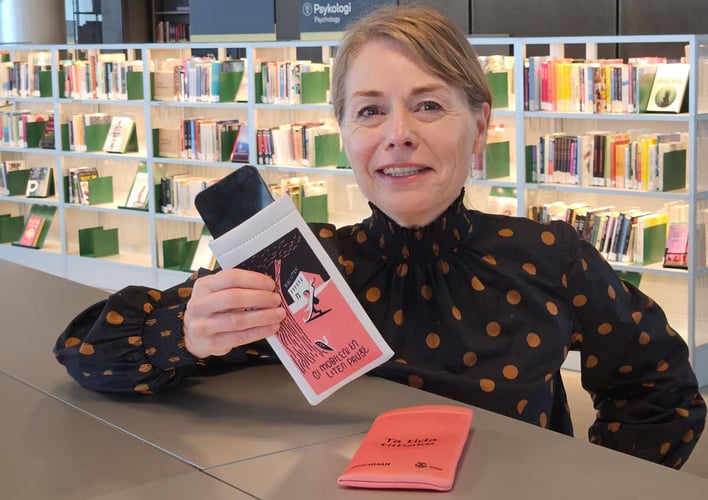 kvinne viser fram en mobilsovepose på et bibliotek