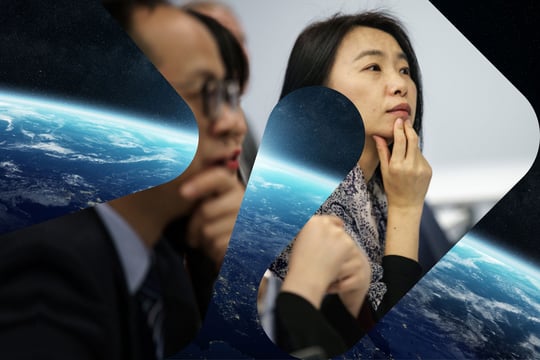 To asiatiske forskere med satelittbilde av jordkloden i bakgrunnen